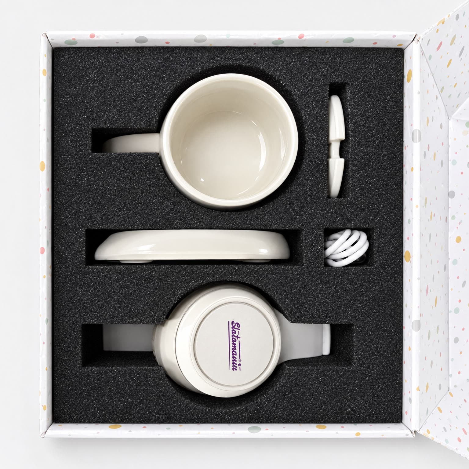 Foam-fitted gift kit with a mug, charger, and headphones